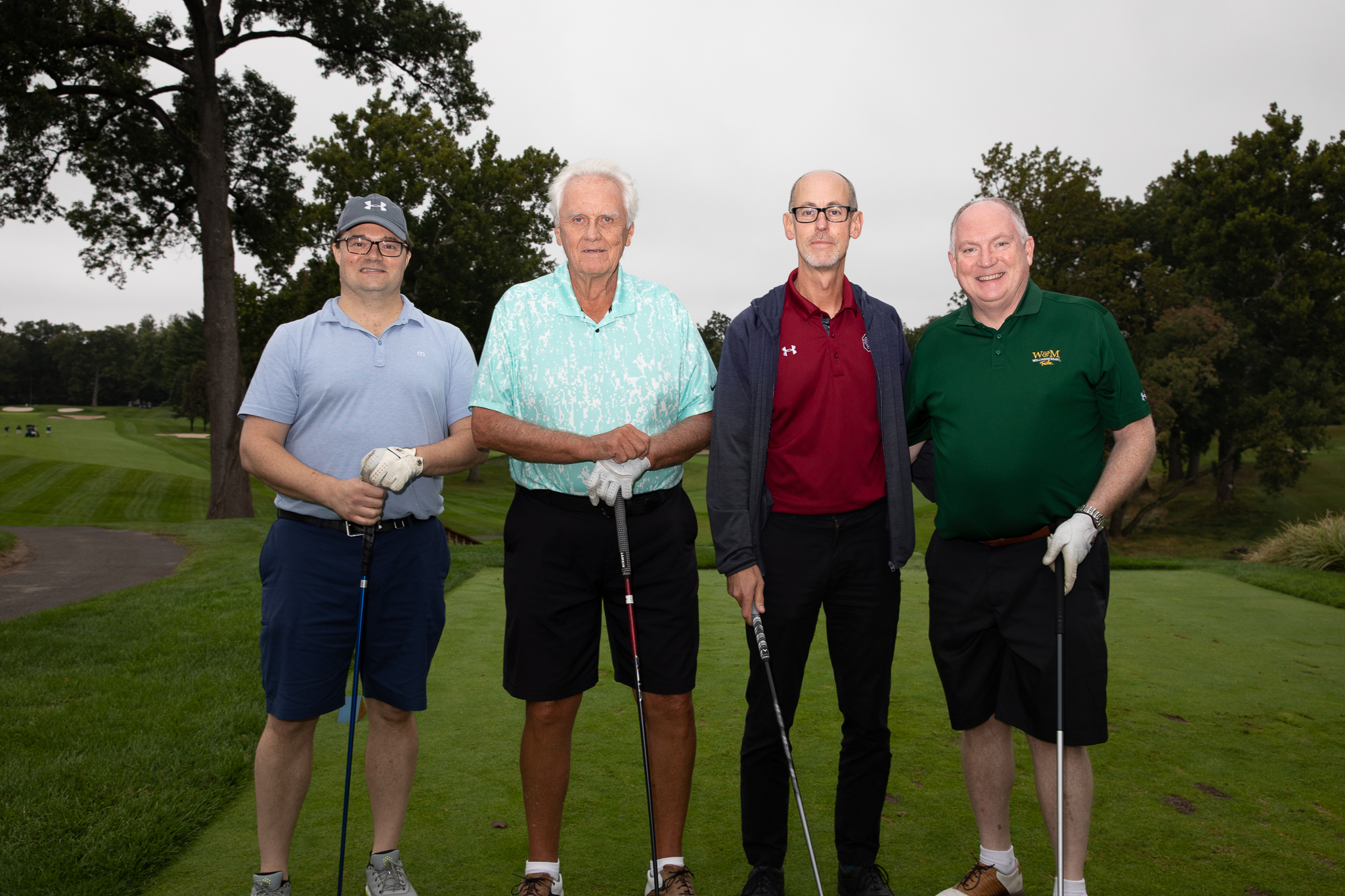 Bill and Pete pose with other golfers on the green during a charity golf tournament